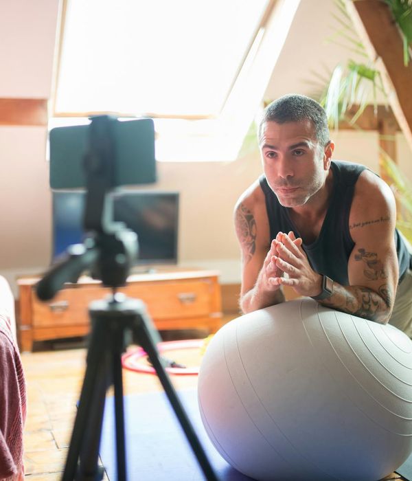 Man performing stability exercises in a dark modern studio environment.